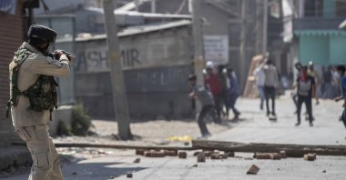 An Indian paramilitary soldier aims his pellet gun on Kashmiri protesters marching on the streets in solidarity with rebels engaged in a gunbattle with soldiers, in Srinagar, Indian controlled Kashmir, Sept. 17, 2020. (AP Photo)