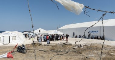 People from the destroyed Moria camp stand outside United Nations High Commissioner for Refugees (UNHCR) tents at a new temporary camp on the island of Lesbos, Greece, Sept. 24, 2020 (AA Photo)