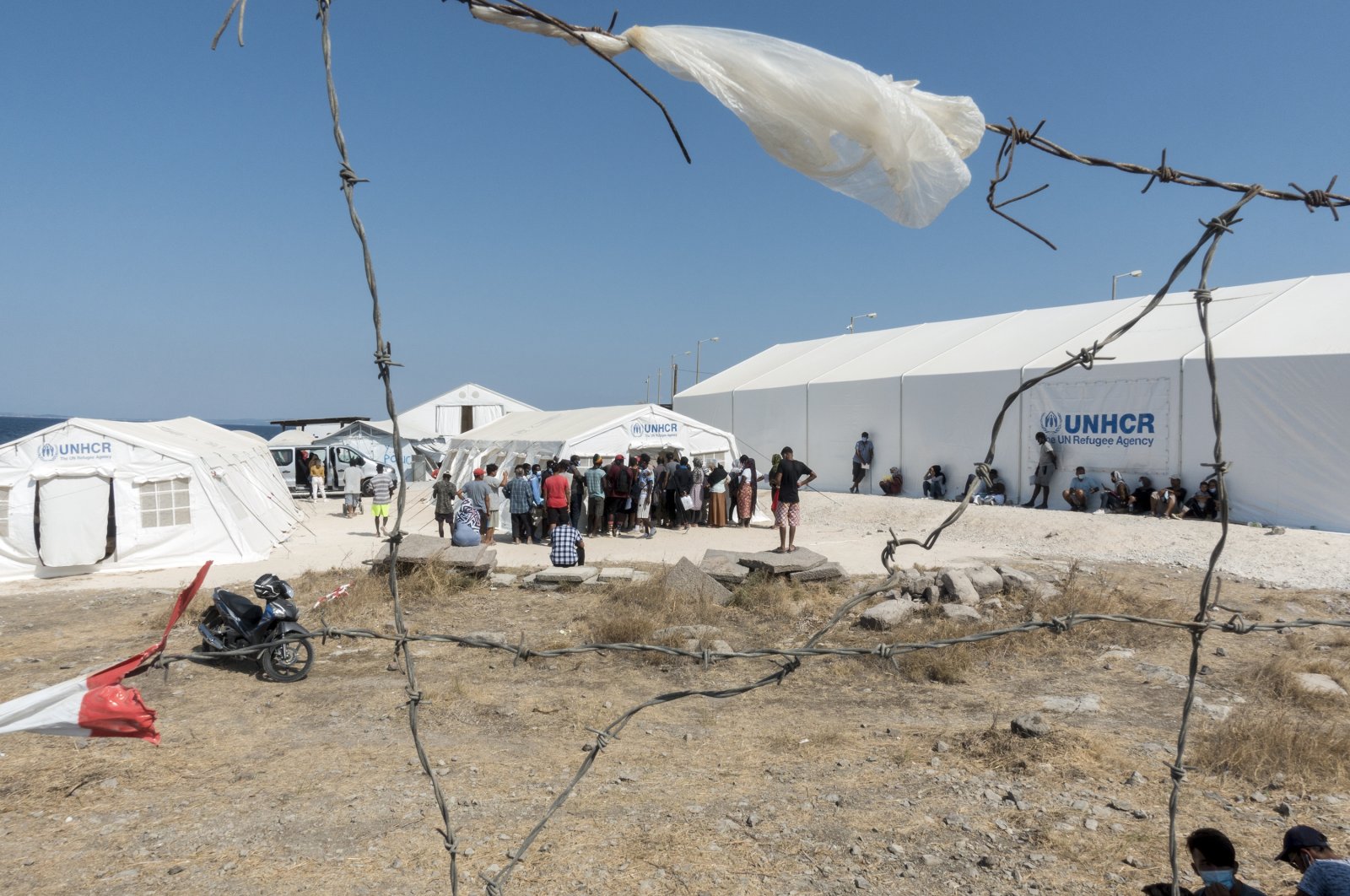 People from the destroyed Moria camp stand outside United Nations High Commissioner for Refugees (UNHCR) tents at a new temporary camp on the island of Lesbos, Greece, Sept. 24, 2020 (AA Photo)