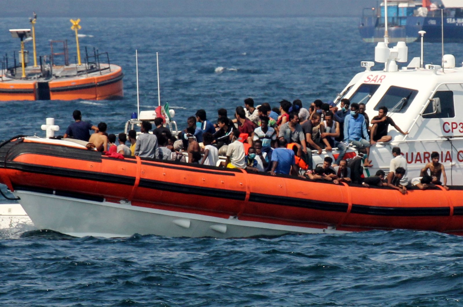 A patrol boat of the Italian Coast Guards (Guardia Costiera) transports migrants towards the port of Palermo, Sicily after they rescued them at sea after a group of 76 migrants threw themselves into the water from the rescue vessel of Spanish non-governmental organization Open Arms, off Palermo, Sicily, Italy, Sept. 17, 2020. (AFP Photo)