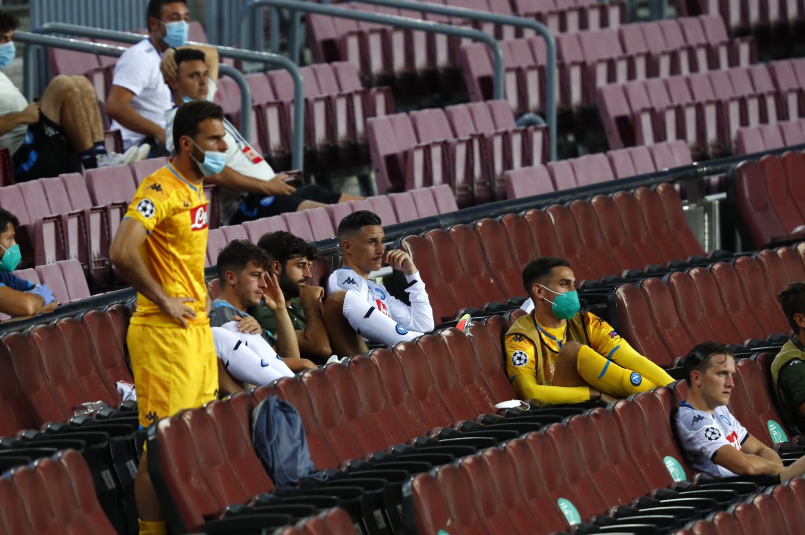 Napoli substitutes sit in the stands during a Champions League match against Barcelona, in Barcelona, Spain, Aug. 8, 2020. (AP Photo)
