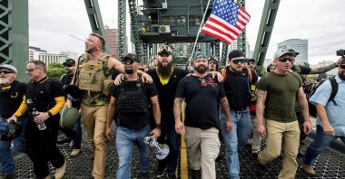 In this Aug. 17, 2019, file photo, members of the Proud Boys and other right-wing demonstrators march across the Hawthorne Bridge during a rally in Portland. At least several thousand people are expected in Portland on Sept. 26, 2020, for a rally in support of President Donald Trump and his re-election campaign as tensions boil over nationwide following the decision not to charge officers for killing Breonna Taylor. (AP Photo)