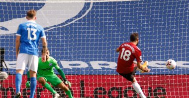 Manchester United's Portuguese midfielder Bruno Fernandes (R) takes a penalty and scores his team's third goal during the English Premier League football match between Brighton and Hove Albion and Manchester United at the American Express Community Stadium in Brighton, southern England on September 26, 2020. (AFP Photo)