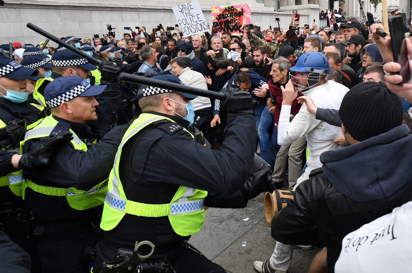 London Police move in to disperse protesters at a 'We Do Not Consent!' mass rally against vaccination and government restrictions designed to fight the spread of the novel coronavirus, including the wearing of masks and taking tests for the virus  in Trafalgar Square, London, Sept. 26, 2020, (AFP Photo)