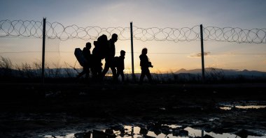 In this file photo, refugees walk to a registration camp after crossing the  Greek-Macedonian border, near the town of Gevgelija, after Macedonia allowed around 250 migrants to cross its border with Greece, as 10,000 more were left waiting in miserable conditions, March 2, 2016. (AFP Photo)