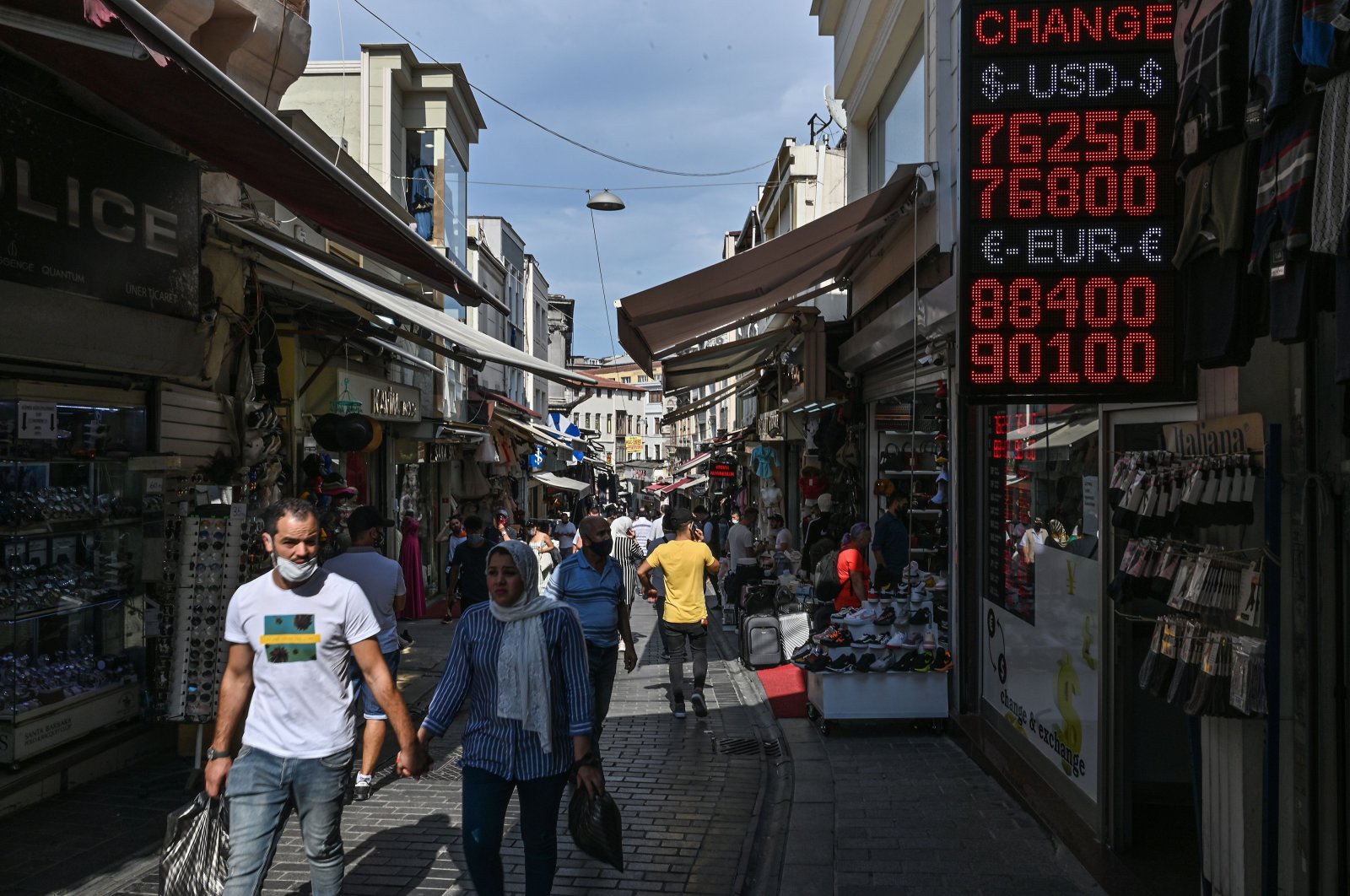 People walk past a screen showing rates at a currency exchange agency near the Grand Bazaar, Istanbul, Sept. 24, 2020. (AFP Photo)