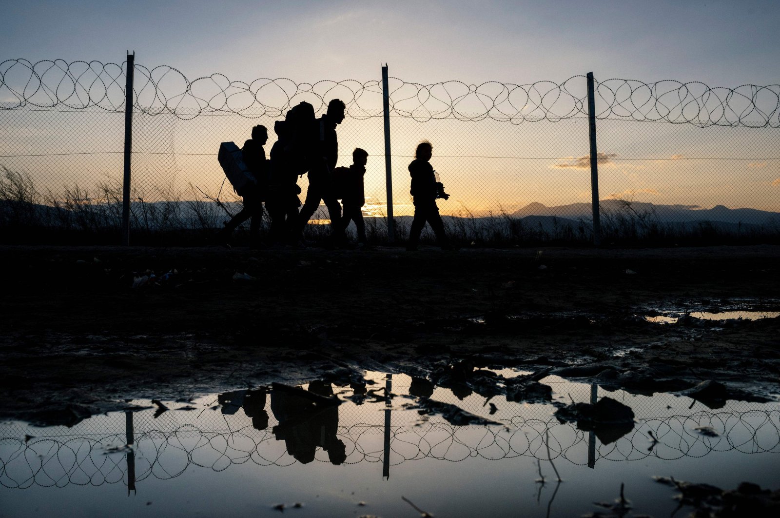 In this file photo, refugees walk to a registration camp after crossing the  Greek-Macedonian border, near the town of Gevgelija, after Macedonia allowed around 250 migrants to cross its border with Greece, as 10,000 more were left waiting in miserable conditions, March 2, 2016. (AFP Photo)