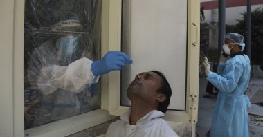 A health worker conducts COVID-19 test at a government hospital, New Delhi, Sept. 28, 2020. (AP Photo)