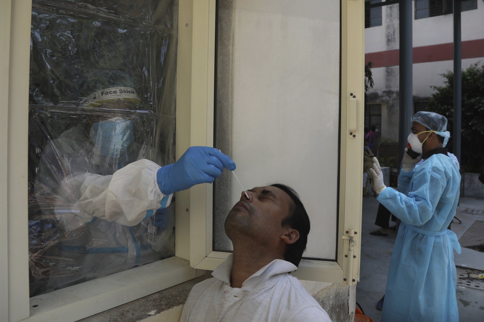 A health worker conducts COVID-19 test at a government hospital, New Delhi, Sept. 28, 2020. (AP Photo)
