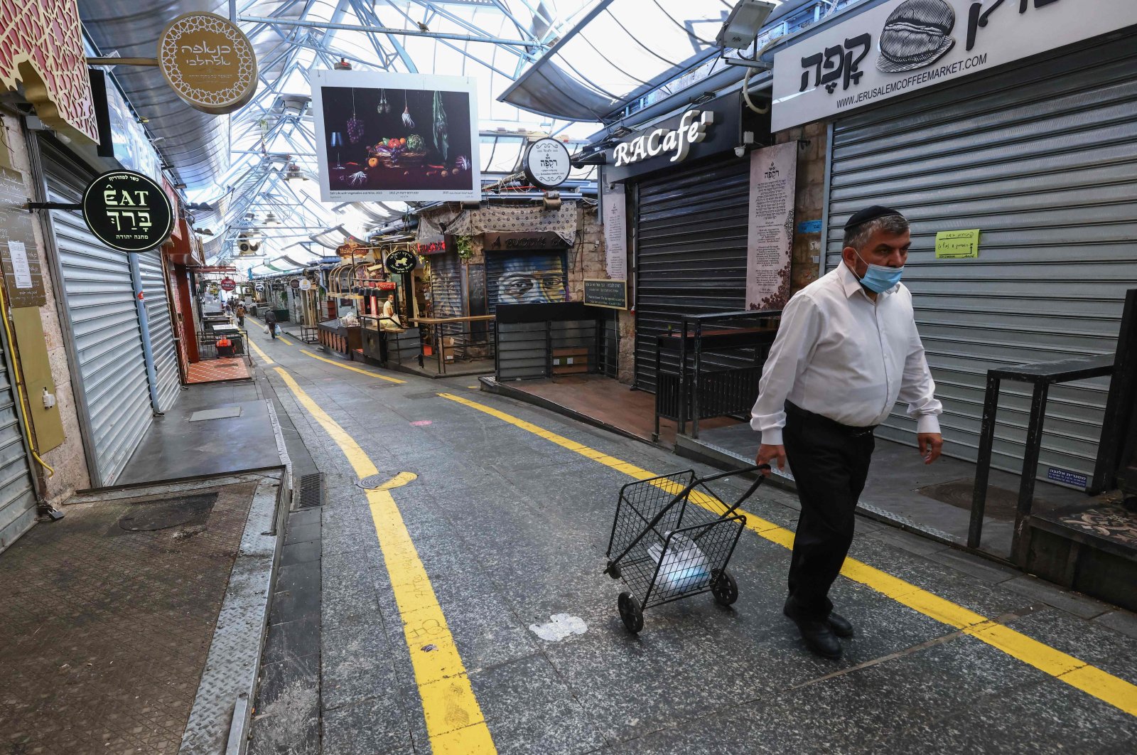 A man walks past closed shops during Jerusalem's main market closure on Sept. 25, 2020. (AFP Photo)