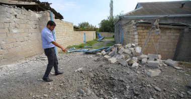 A man points to a crater that was allegedly caused by shelling during the fighting over the Nagorno-Karabakh region, in the Tartar border district of Azerbaijan, Sept. 29, 2020. (REUTERS Photo)