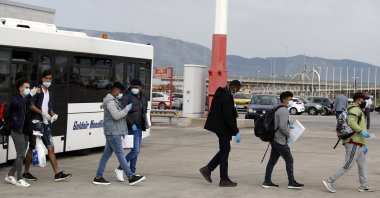 Unaccompanied children refugees wearing face masks board an airplane bound for Britain at the Eleftherios Venizelos International Airport in Athens, Greece, May 11, 2020. (AP Photo)