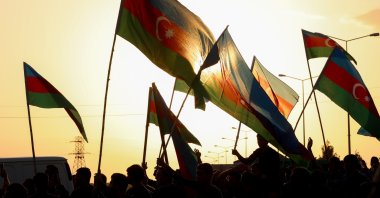 People wave flags at the funeral of a member of Azerbaijani military, who was killed by Armenian shelling in the Tartar border district of Azerbaijan, Sept. 29, 2020. (Photo by Getty Images)