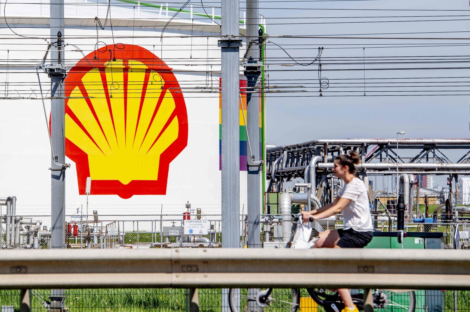 A woman rides her bicycle past the Shell Pernis site in Rotterdam, the Netherlands, July 30, 2020. (AFP Photo)