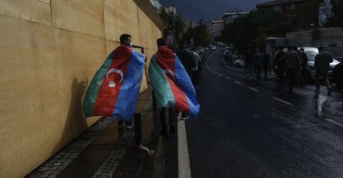 Two Turkish men, draped in Azerbaijani flags, walk away following a protest supporting Azerbaijan against Armenia's aggression, in front of the Azerbaijani Consulate in Istanbul, Turkey, Sept. 29, 2020. (AP Photo)
