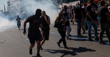 Protesters run from tear gas during a demonstration against the risks of the coronavirus in schools, in Athens, Greece, Oct. 1, 2020. (AFP Photo)