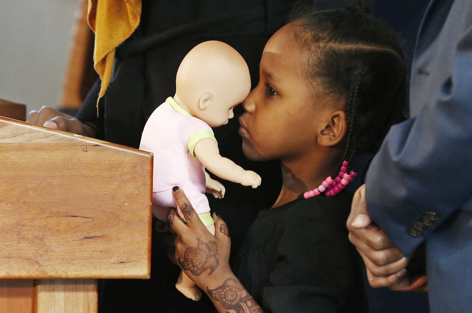 Four-year-old Somali refugee Mushkaad Abdi holds her doll as her mother, Samira Dahir, talks during a Minneapolis news conference one day after she was reunited with her family, Feb. 3, 2017. (AP Photo)