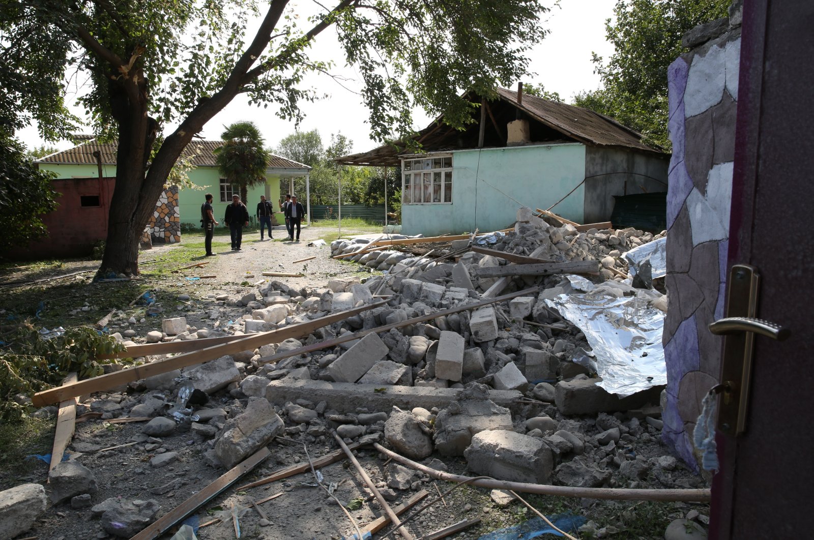 People look at a house destroyed by Armenian shelling in the city of Tartar, Azerbaijan, Sept. 29, 2020. (EPA Photo)