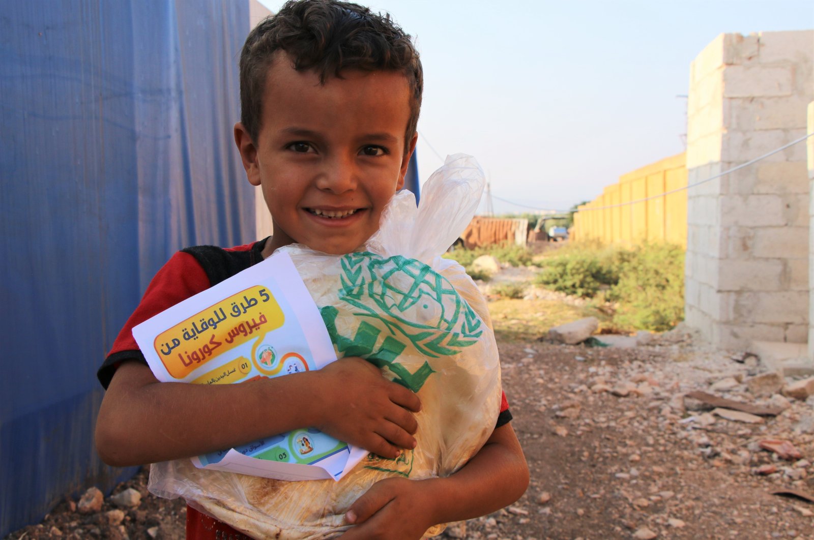 A Syrian child hugs the bread package delivered by Turkey's Humanitarian Relief Foundation (IHH), northern Syria, Oct. 1, 2020. (AA)