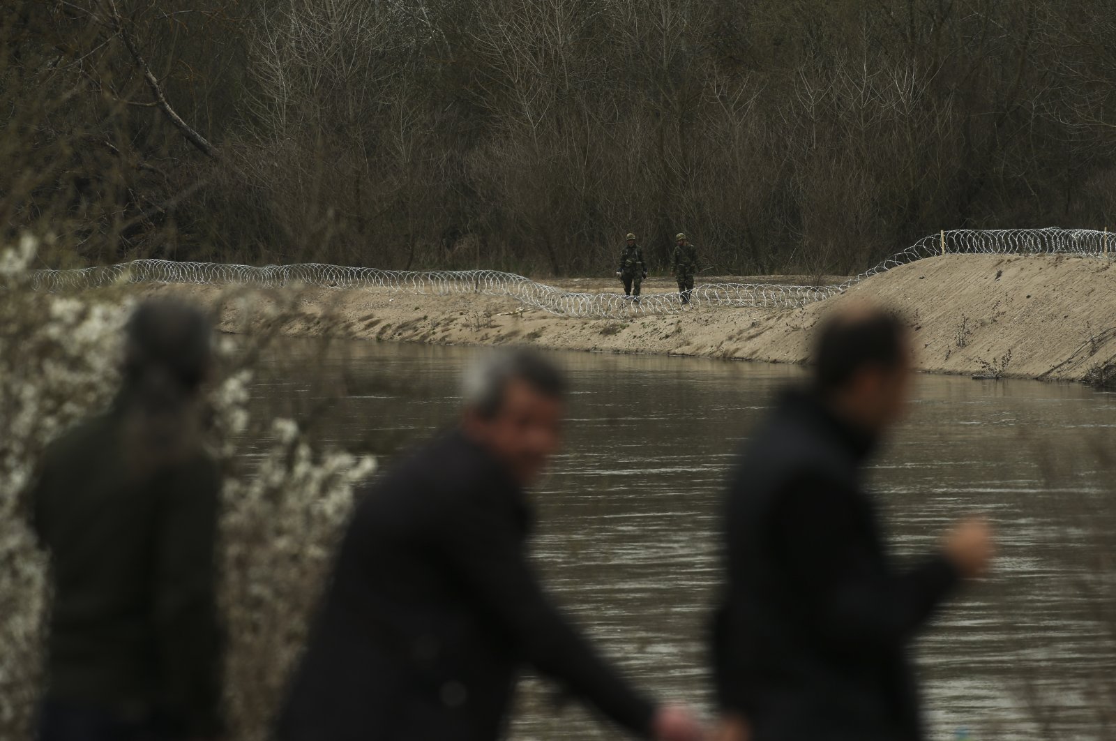 Greek Army soldiers set up barbed wire along the Greek side of the Maritsa river at the Turkish-Greek border near Doyran village, Edirne region, Turkey, Tuesday, March 10, 2020.(AP Photo)