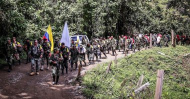Handout picture released by the Revolutionary Armed Forces of Colombia (FARC) showing Commander Pablo Catatumbo leading rebels arriving to hand in their weapons in Buenos Aires, Cauca Department, Colombia on Jan. 1, 2017. (FARC Photo via AFP)