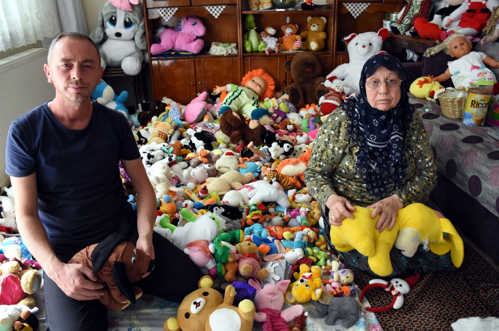 Muammer Kavazoğlu (L) and his mother Şükriye pose with toys they are fixing, in Bursa, northwestern Turkey, Oct. 2, 2020. (AA Photo) 