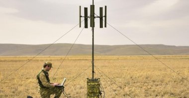 A Turkish soldier stands near a PUHU system set up on field in an unknow date and location. (IHA Photo)