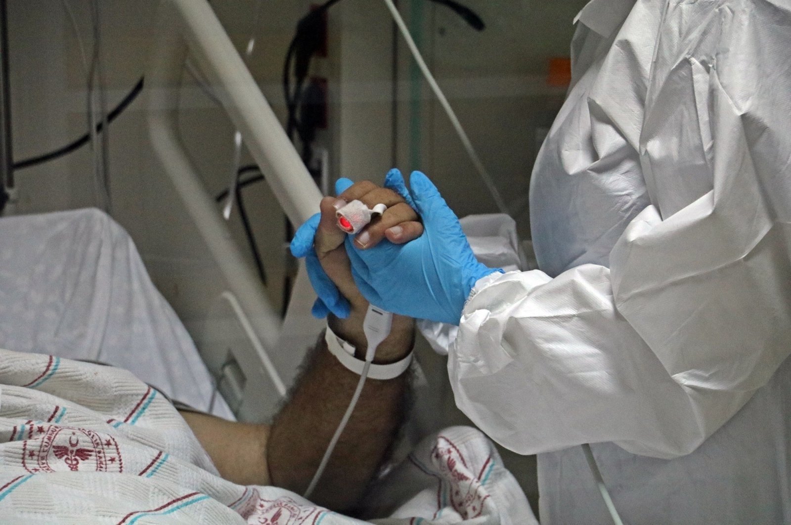 Dr. Ayça Gümüş holds her patient's hand in the intensive care unit at the Kepez Public Hospital in the southern Turkish province of Antalya on Sunday, Oct. 4, 2020 (IHA Photo)