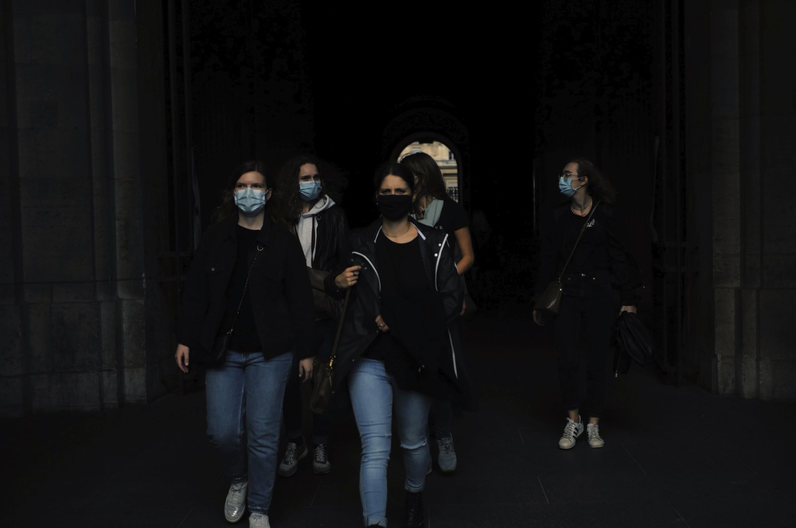 People wearing protective face mask as a precaution against the coronavirus walk in the courtyard of the Louvre museum, Paris, Oct. 1, 2020. (AP Photo)