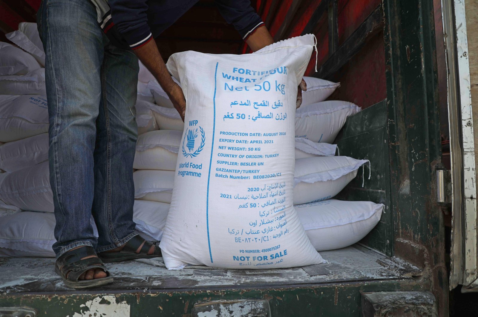 A man unloads bags of fortified flour from an international humanitarian aid truck that crossed into Syria's northwestern Idlib province through the Bab al-Hawa border crossing with Turkey, Sept. 7, 2020. (AFP Photo)