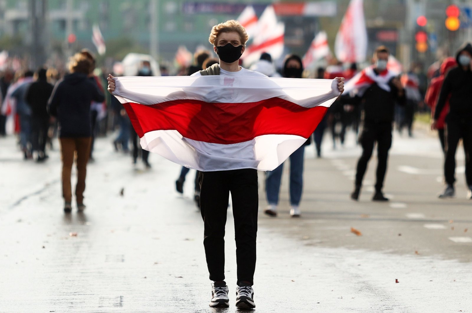 A man carries a former white-red-white flag of Belarus during a rally demanding to free jailed activists of the opposition in Minsk, Belarus, Oct. 4, 2020. (AFP Photo)