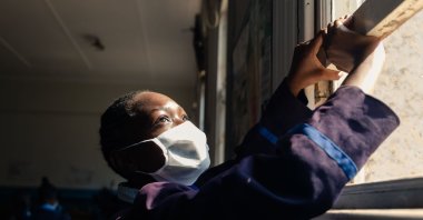 A pupil opens a window for fresh air circulation in the class room ahead of the first day of the resumption of classes at Queen Elizabeth School in Harare on September 28, 2020. (AFP Photo)