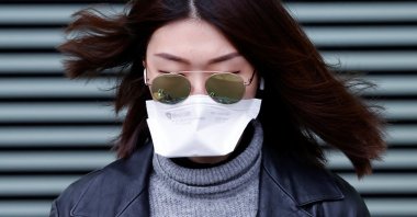 A woman wearing a face mask leaves XIII district police station in Paris, after a suspected coronavirus case was examined, France February 24, 2020. (Reuters Photo)