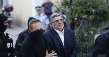 Far-right Golden Dawn party leader Nikos Mihaloliakos (R) is escorted by anti-terrorism police officers as he arrives at a courthouse in Athens, Greece, Sept. 28, 2013. (Reuters Photo)