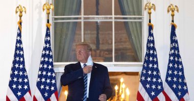 U.S. President Donald Trump removes his mask upon return to the White House from Walter Reed National Military Medical Center in Washington, D.C., on Oct. 5, 2020. (AFP Photo)