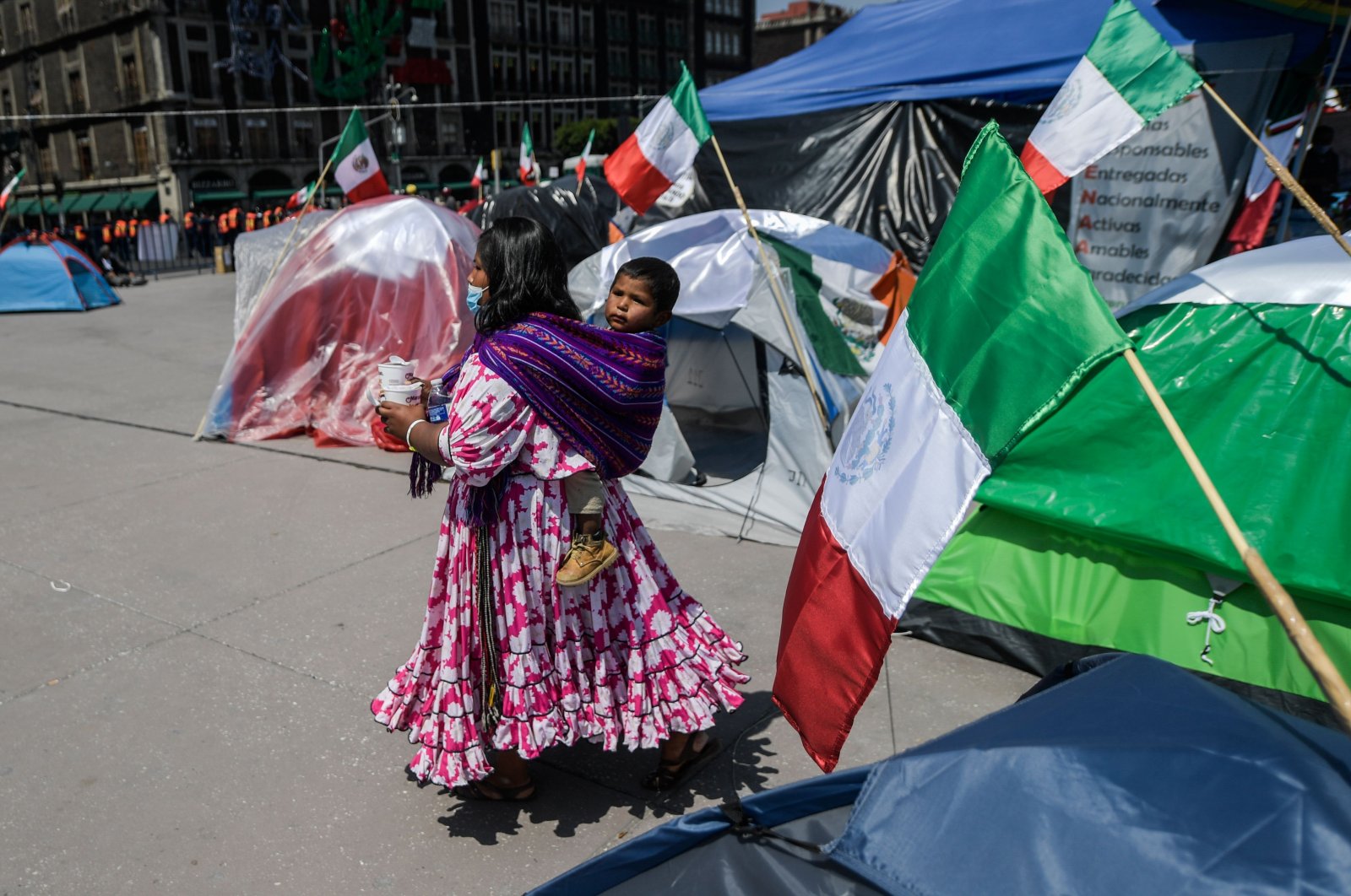 A woman of the Raramuri ethnic group walks amid tents set up by members of the National Front Anti-AMLO to protest against Mexican President Andres Manuel Lopez Obrador at Zocalo Square in Mexico City, on Oct. 5, 2020. (AFP Photo)