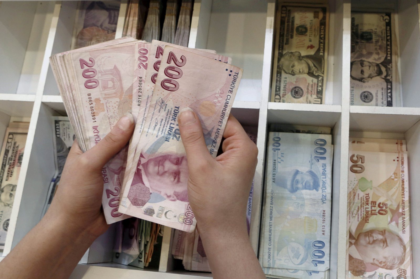 A money changer counts Turkish lira bills at a currency exchange office in central Istanbul, Turkey, Aug. 21, 2015. (Reuters Photo)