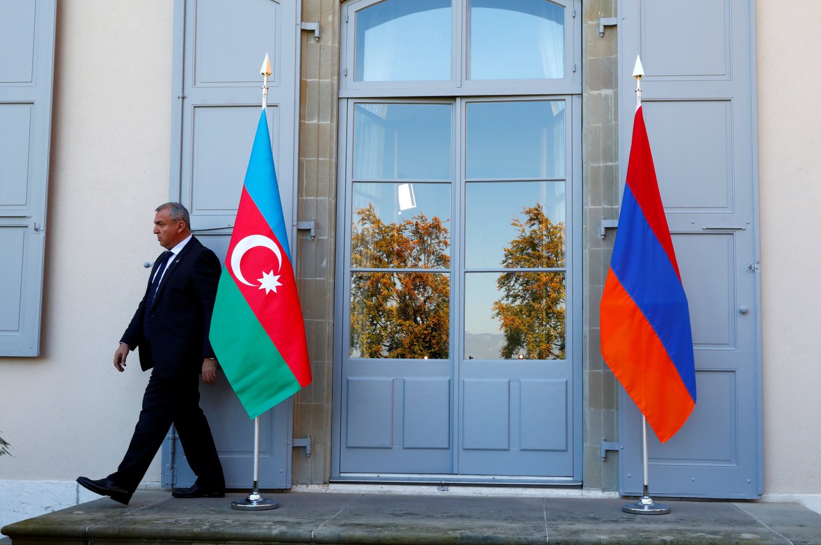 A security guard walks past an Azerbaijan (L) and Armenian flag at the opening of talks of the Organization for Security and Co-operation in Europe (OSCE) Minsk group in Geneva, Switzerland, Oct. 16, 2017. (Reuters Photo)