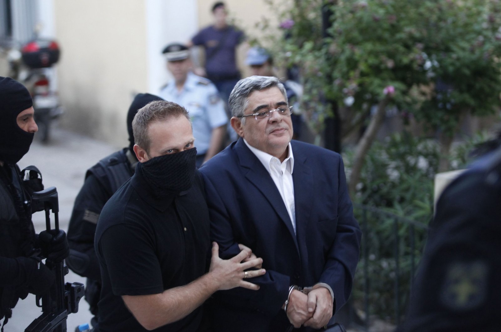 Far-right Golden Dawn party leader Nikos Mihaloliakos (R) is escorted by anti-terrorism police officers as he arrives at a courthouse in Athens, Greece, Sept. 28, 2013. (Reuters Photo)