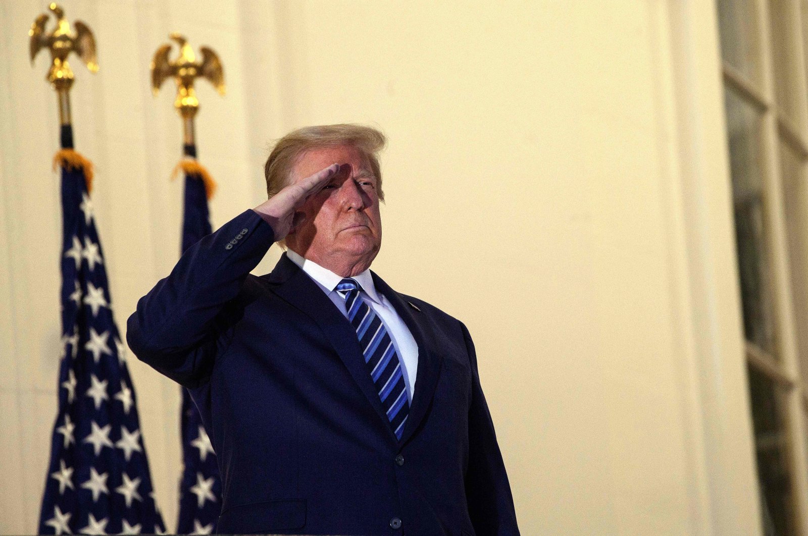 U.S. President Donald Trump salutes from the Truman Balcony upon his return to the White House from Walter Reed Medical Center, Washington, D.C., Oct. 5, 2020. (AFP Photo)