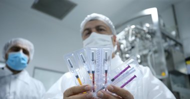 Health Minister Fahrettin Koca shows a vaccine in development by Koçak Farma company, in Tekirdağ, northwestern Turkey, Oct. 3, 2020. (AA Photo)