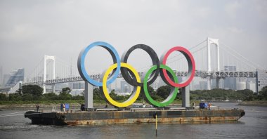 A barge carries the Olympic rings for maintenance due to postponement of the Tokyo 2020 Games, in Tokyo, Japan, Aug. 6, 2020.