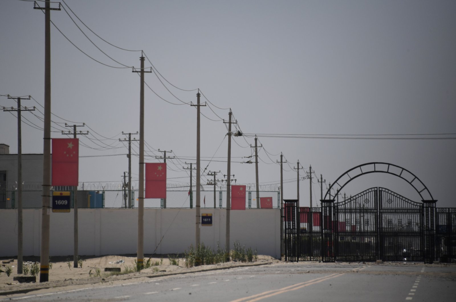 Chinese flags are seen on a road leading to a facility believed to be a reeducation camp where mostly Muslim ethnic minorities are detained, on the outskirts of Hotan in China's northwestern Xinjiang region, May 31, 2019. (AFP Photo)