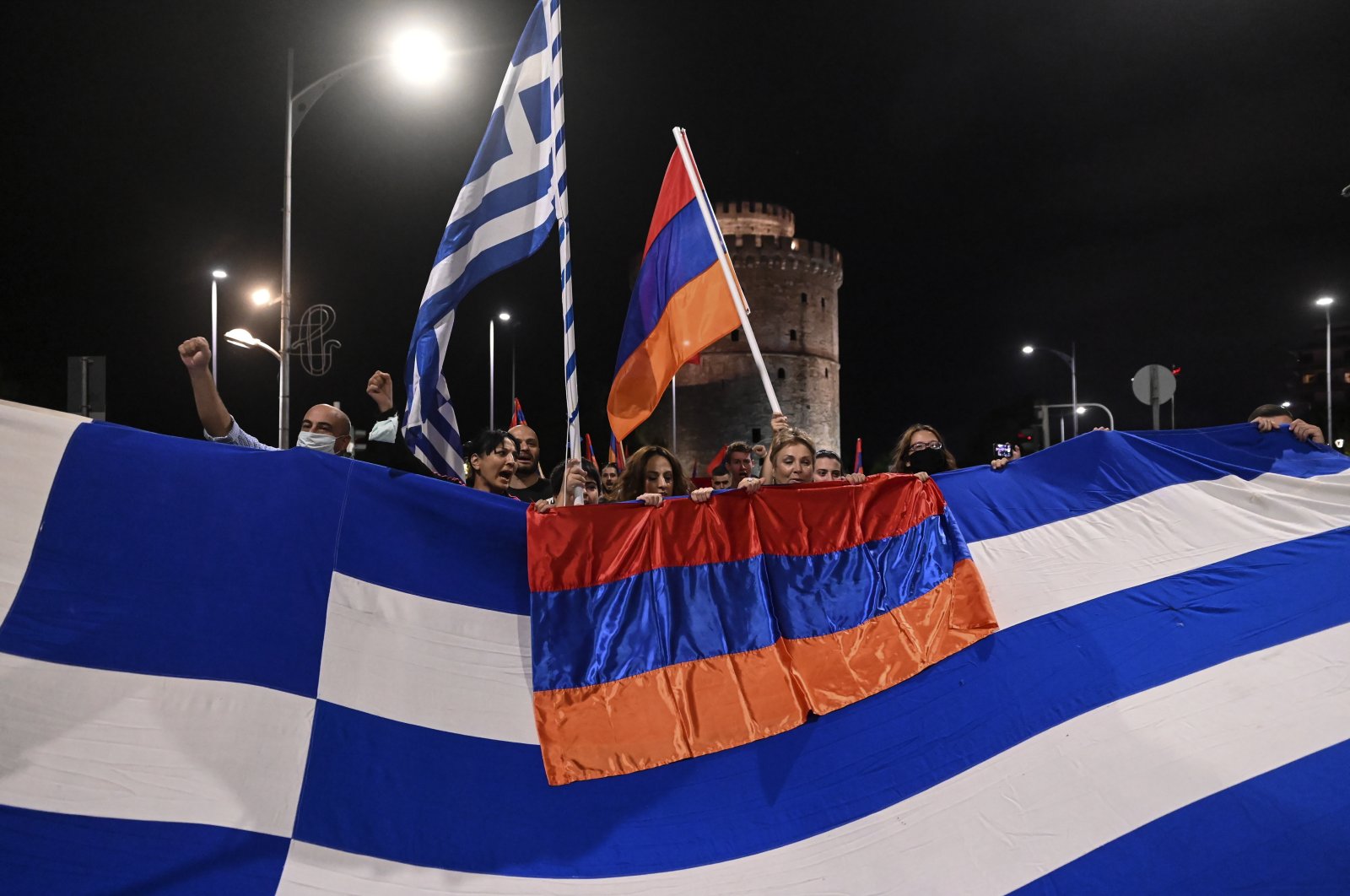 Pro-Armenian protesters stand behind a Greek and an Armenian flag during a demonstration in support of Armenia, in the northern city of Thessaloniki, Greece, Oct. 3, 2020. (AP Photo)