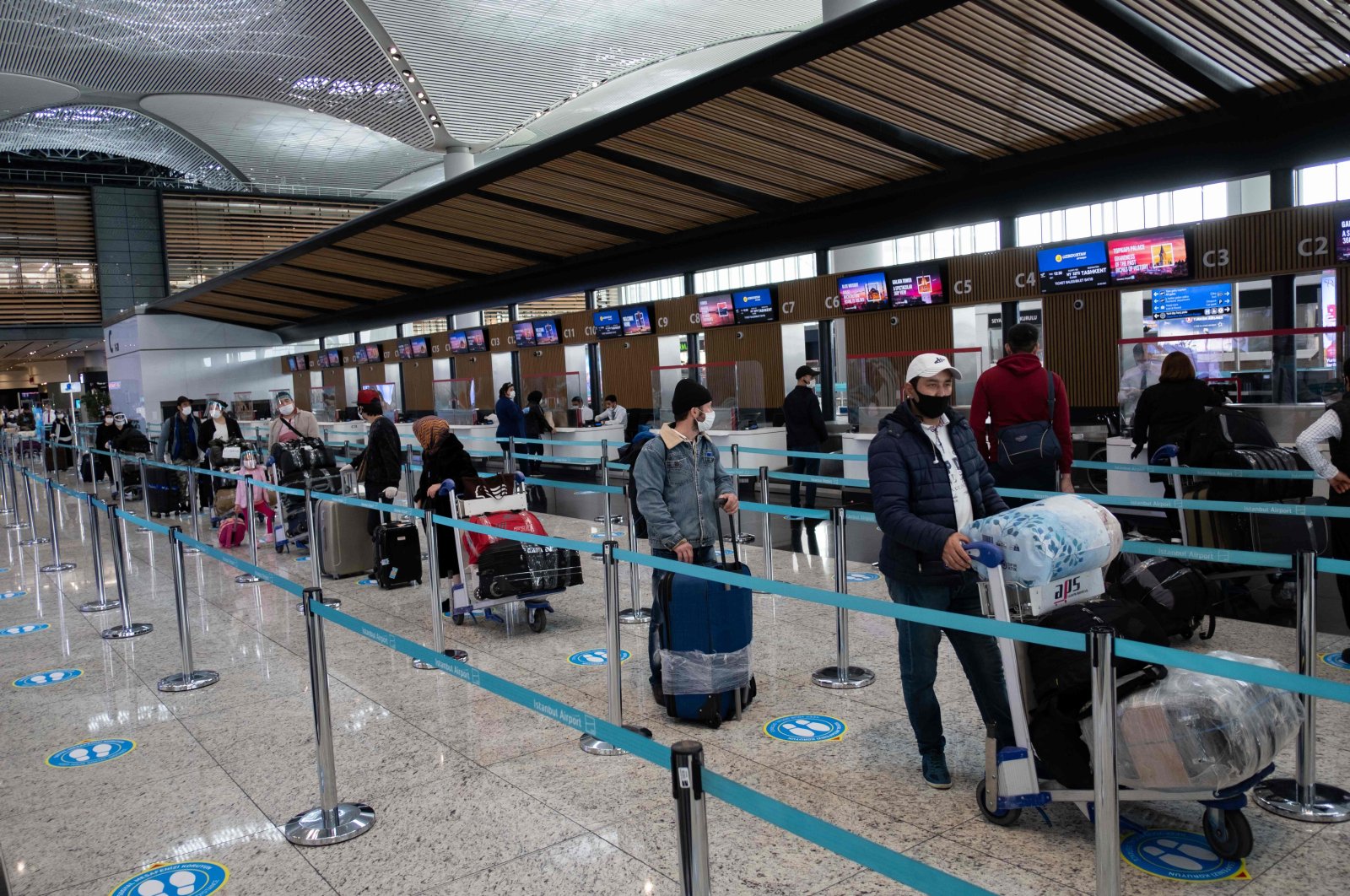 Passengers wearing protective masks wait to be checked in at Istanbul Airport, Istanbul, Turkey, June 1, 2020. (AFP Photo)