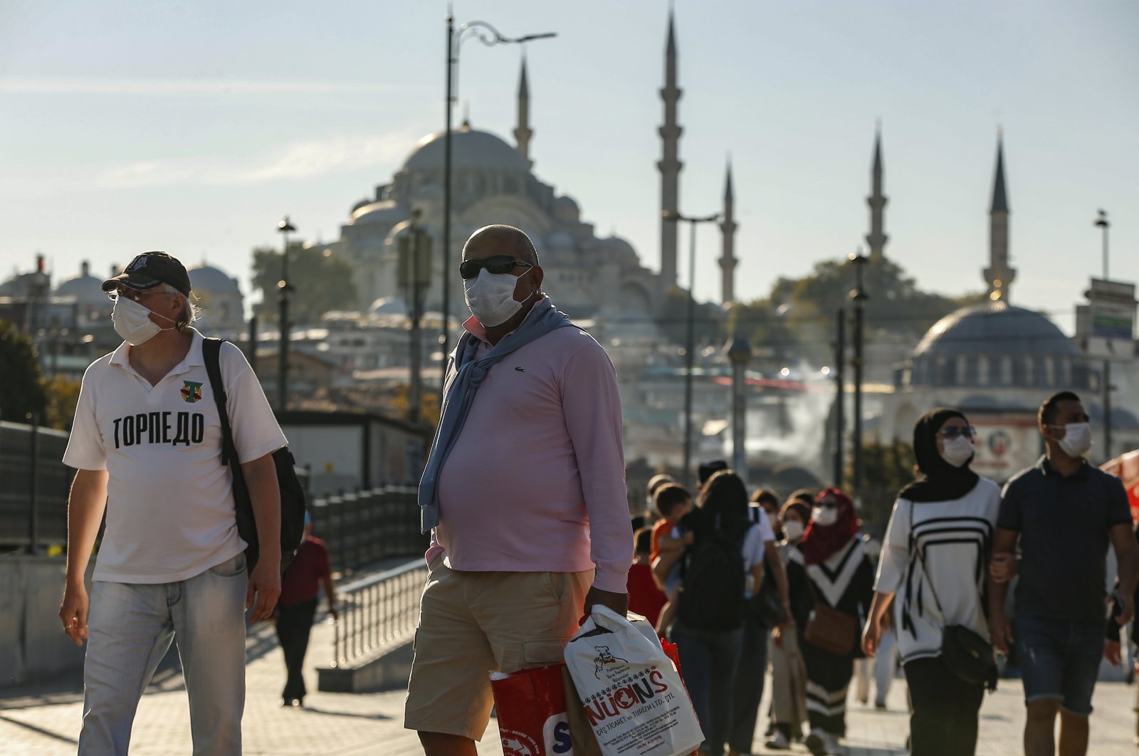 People, wearing masks to help protect against the spread of the coronavirus, walk in Istanbul, Friday, Oct. 2, 2020. (AP Photo)
