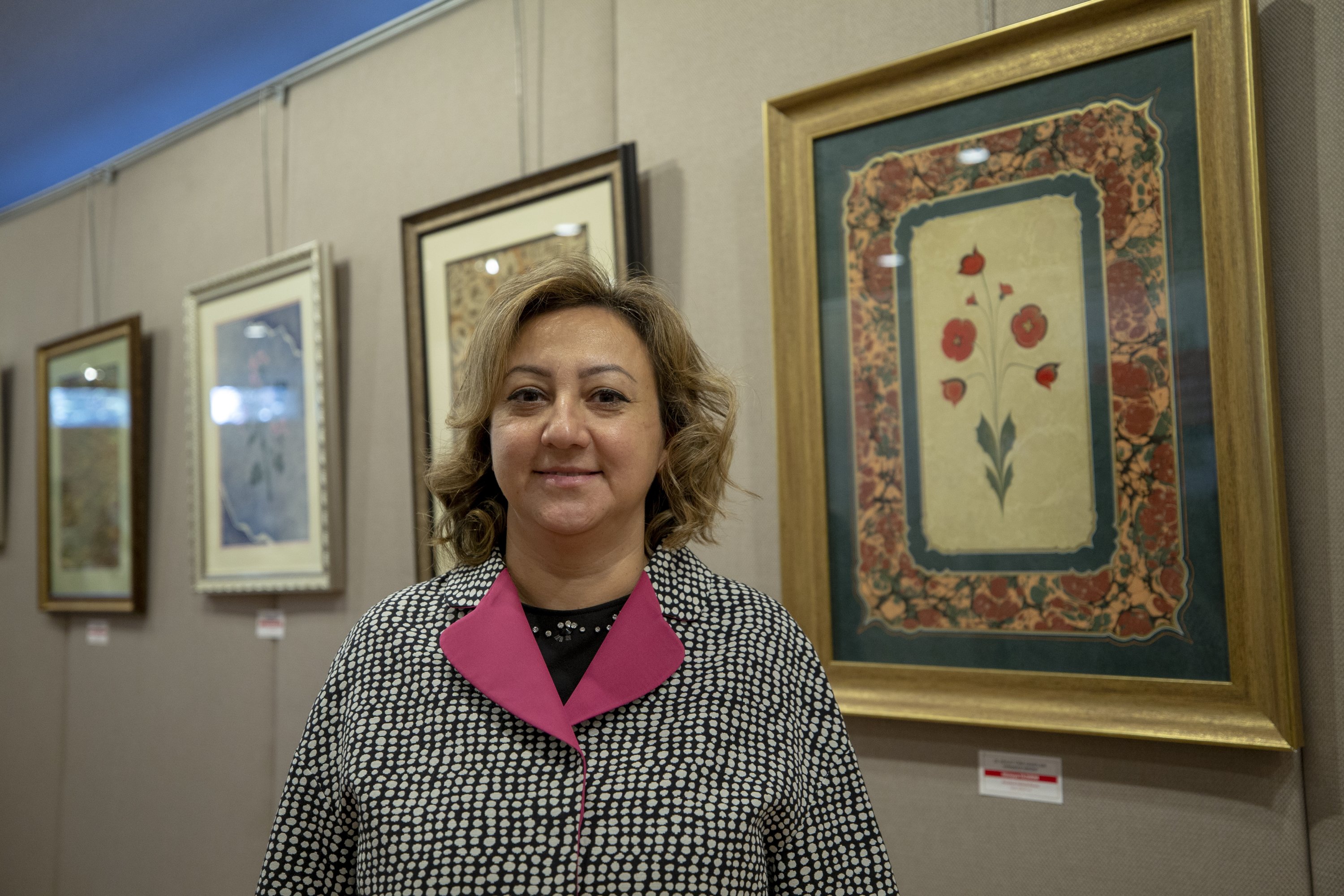 Deputy Minister of Culture and Tourism Özgül Özkan Yavuz poses with some works at the exhibition at the National Library, the capital Ankara, Turkey, Oct. 7, 2020. (AA PHOTO)