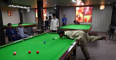 Muhammad Ikram plays a shot with his chin at a local snooker club in Samundri, Pakistan, Sept. 28, 2020. (AFP Photo) 