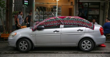 People in Üsküdar were seen covering their cars with carpets and rugs to shield their cars from a sudden hailstorm in Istanbul, Oct. 8, 2020. (AA Photo)