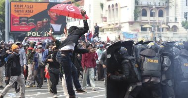 A protester tries to hurl a brick toward police trying block protesters from advancing on the presidential palace during a rally in Jakarta, Indonesia, Oct. 8, 2020. (AP Photo)